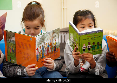 Élèves de l'école primaire de lire des livres sur le vivre en Afrique. Banque D'Images