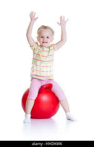 Smiling little girl jumping on a big ball isolé sur fond blanc Banque D'Images