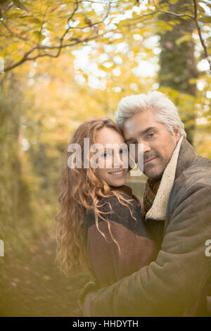 Affectueux Portrait couple hugging in autumn woods Banque D'Images