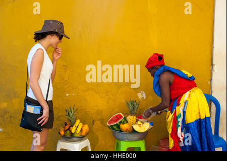 Femme vêtue de vêtements traditionnels pour la coupe et la vente de fruits dans la pittoresque vieille ville de Carthagène, Colombie Banque D'Images