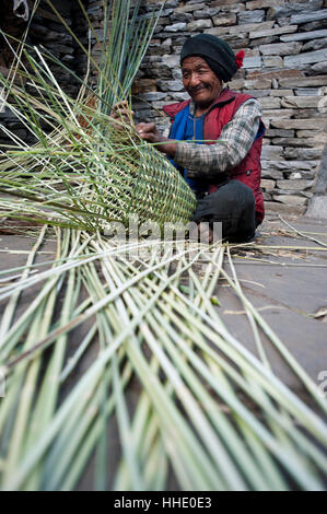 Un homme utilise beaucoup de compétence et de connaissances traditionnelles pour faire un panier de bambou (Doko) à la main, Région Manaslu, Népal Banque D'Images