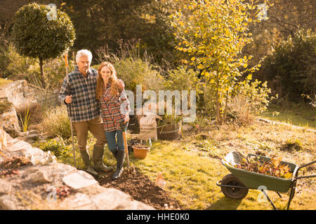 Portrait of smiling couple jardinage au jardin d'automne ensoleillée Banque D'Images