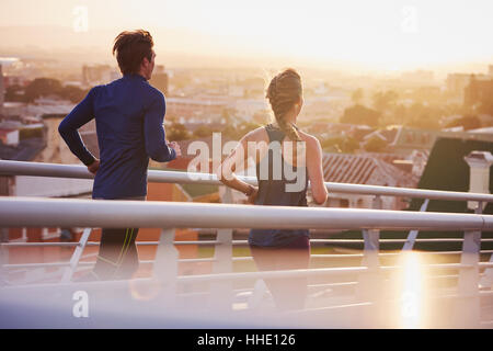 Runner couple running sur passerelle avec vue sur la ville Banque D'Images