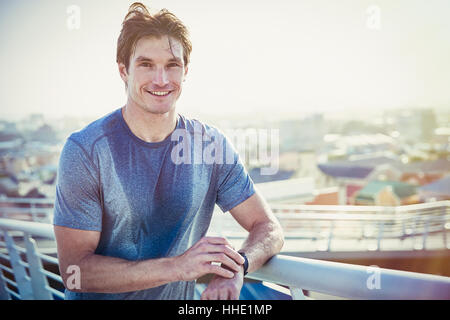 Certains hommes en sueur Portrait runner avec smart watch tracker sur sunny fitness passerelle urbaine Banque D'Images