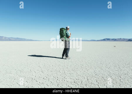 Randonnée en backpacker mâle vaste désert, Black Rock Desert, Nevada Banque D'Images