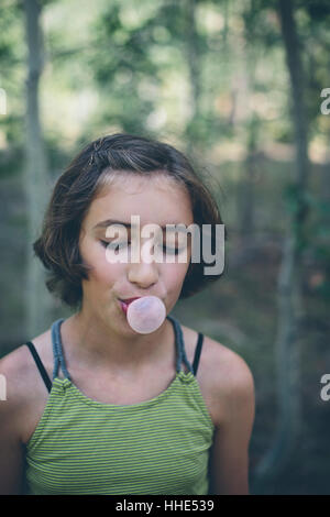 Onze ans girl blowing bubble gum bubble Banque D'Images