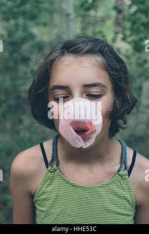 Onze ans girl blowing bubble gum bubble Banque D'Images