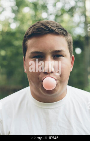 Portrait of woman blowing bubble gum bubble Banque D'Images