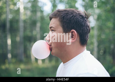 Portrait of woman blowing bubble gum bubble Banque D'Images