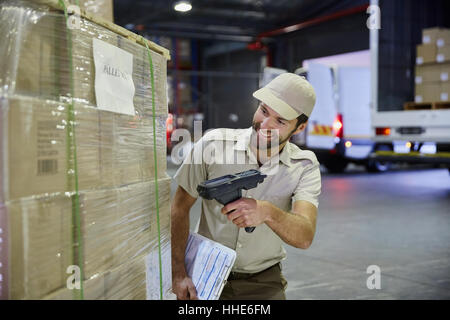 Chauffeur de camion palette balayage travailleur de boîtes de carton au quai de chargement de l'entrepôt de distribution Banque D'Images