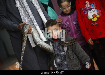 Giza, Egypte. 19 Jan, 2017. Un garçon pose pour une photo avec un python sur son épaule à Tolba's zoo privé à Gizeh, Egypte. Africano Tolba Village est un zoo privé établi par 50-year-old hunter Salah Tolba. Il a décidé de transformer son hobby en une exposition d'animaux rares d'affaires par l'intermédiaire d'un zoo privé sous licence. Source : Xinhua/Alamy Live News Banque D'Images