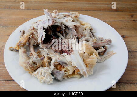 Carcasse de poulet rôti demeure sur une plaque sur une table en bois Banque D'Images