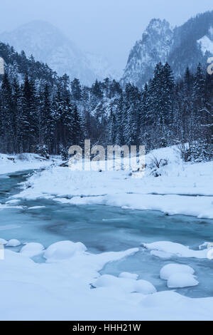 Rivière gelée avec des montagnes en arrière-plan, l'hiver, Nationalpark Gesäuse, Styrie, Autriche Banque D'Images