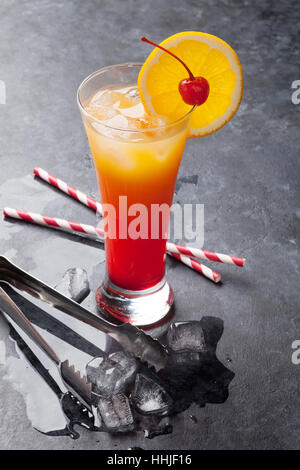 Tequila Sunrise cocktail sur la table en pierre sombre Banque D'Images