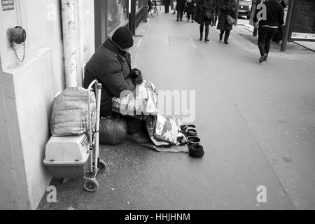 Sans-abri mendier de l'argent avec ses chats, dans les rues de Paris Banque D'Images