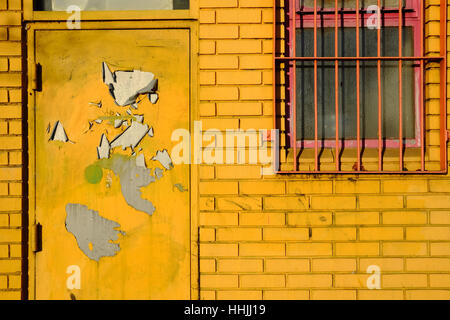 Mur de brique jaune et porte, fenêtre de prescription de fer Banque D'Images