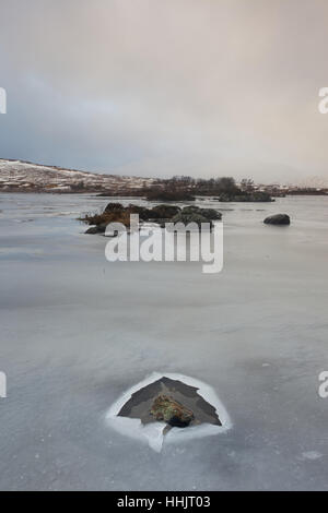 Un petit Lochan sur Rannock Moor en janvier couvert de glace Banque D'Images