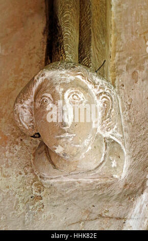 Une tête de pierre sculptée dans le support de l'Afrique du porche de l'église paroissiale de North Elmham, Norfolk, Angleterre, Royaume-Uni. Banque D'Images