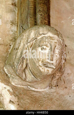 Une tête de pierre sculptée dans le support de l'Afrique du porche de l'église paroissiale de North Elmham, Norfolk, Angleterre, Royaume-Uni. Banque D'Images