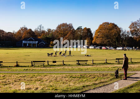 Un passant par une femme montres fitness class sur le terrain de cricket sur Tunbridge Wells, Royal Tunbridge Wells, Kent, UK Banque D'Images