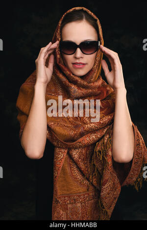 Belle arabe caucasian woman wearing sunglasses. Fond sombre Banque D'Images