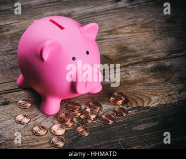 Cochon rose argent fort avec pièces de monnaie sur la table en bois Banque D'Images