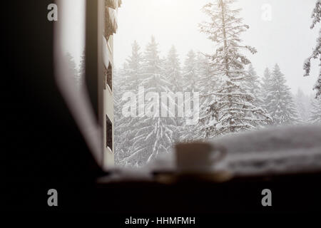 Mug avec thé et café sur le rebord de la fenêtre de la neige en hiver w Banque D'Images