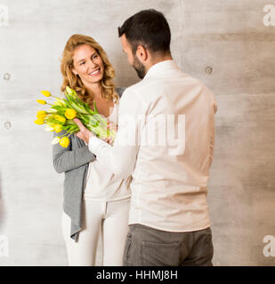 Jeune homme donnant à la fille un bouquet de tulipes Banque D'Images