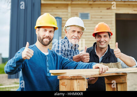 L'équipe d'artisans réussie holding Thumbs up en signe de coopération Banque D'Images