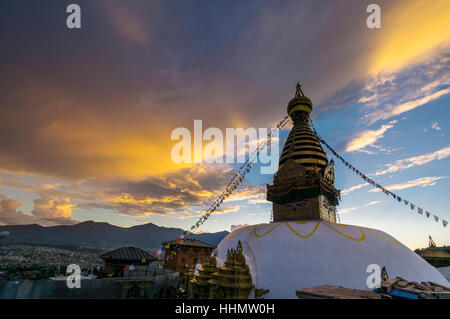 Stupa de Swayambhunath temple, Monkey Temple, décoré de drapeaux de prière tibetains, nuages orange au-dessus, Katmandou, Népal Banque D'Images