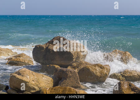 De gros rochers avec des vagues se briser sur eux avec spray. Mer Méditerranée à Chypre. Banque D'Images