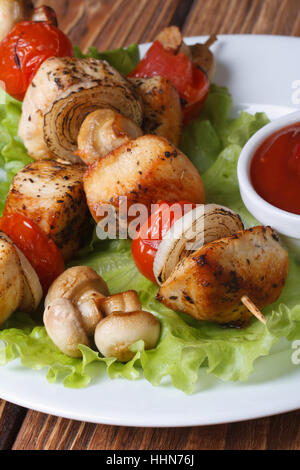 Brochettes de poulet délicieux avec des légumes et des champignons sur les brochettes sur une assiette avec la sauce. vertical. Banque D'Images