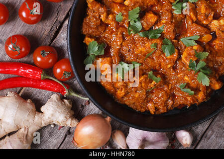 Morceaux de filet de poulet au curry ingrédients de la sauce dans une casserole avec l'ancienne table top view close-up l'horizontale Banque D'Images