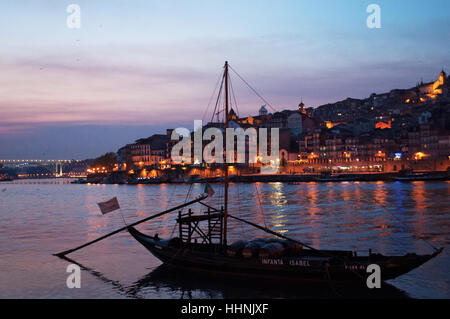Portugal : bateaux après le coucher du soleil et la nuit des toits de Porto, avec vue sur le fleuve Douro Banque D'Images