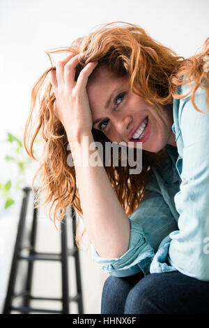 Smiling Caucasian woman with hand in hair Banque D'Images