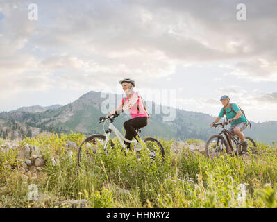 Caucasian couple riding mountain bikes Banque D'Images