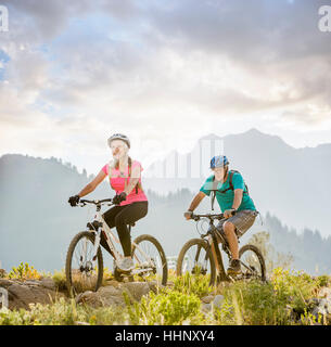 Caucasian couple riding mountain bikes Banque D'Images