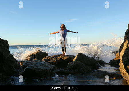 Asian woman standing on rock at beach Banque D'Images
