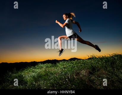 Caucasian woman tournant au coucher du soleil Banque D'Images