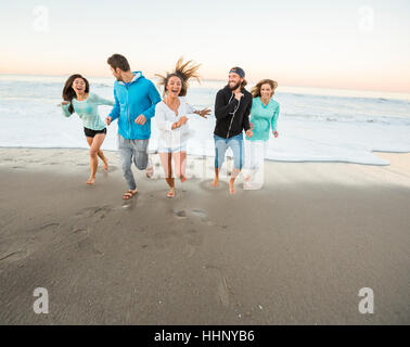 Smiling friends running on beach Banque D'Images
