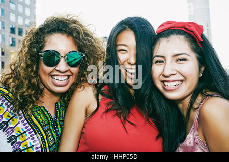 Portrait of women smiling on urban rooftop Banque D'Images