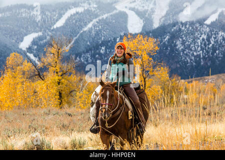 Laughing Caucasian woman riding horse en hiver Banque D'Images