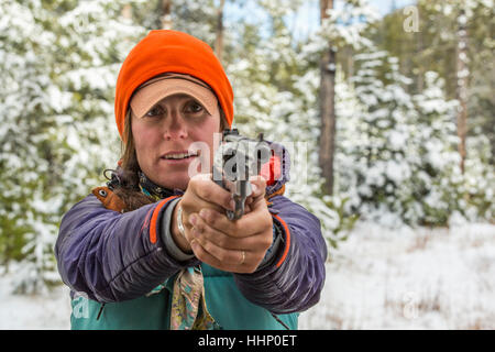 Caucasian woman visant handgun en hiver Banque D'Images