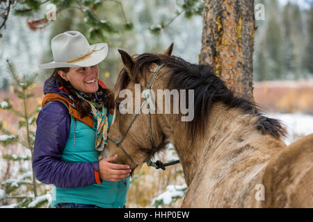 Caucasian woman petting horse en hiver Banque D'Images