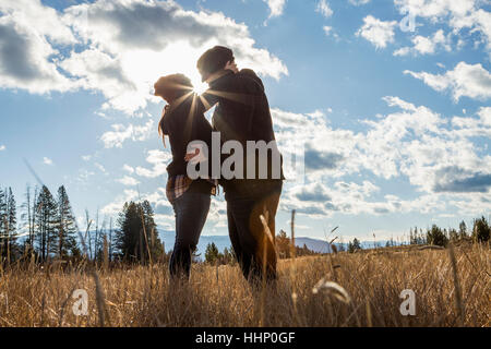 Caucasian couple kissing in champ ensoleillé Banque D'Images