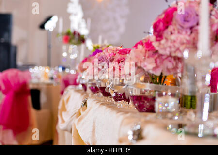 Des arrangements avec des fleurs roses sur la table côté lumière Banque D'Images