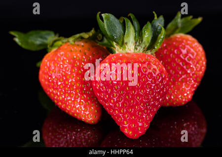 Trois fraises sur noir Banque D'Images