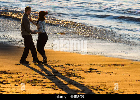 Aberystwyth, Pays de Galles, Royaume-Uni. 20 janvier 2017. Météo France : à la fin d'une journée sans nuages clair et froid, deux jeunes gens danser ensemble au coucher du soleil sur la plage d'Aberystwyth sur l'ouest du pays de Galles cioast Crédit photo : Keith Morris/Alamy Live News Banque D'Images