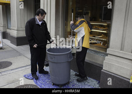 Washington, District de Columbia, Etats-Unis. 20 Jan, 2017. Les gestionnaires de perturber20 balayage Au Bon Pain de la fenêtre de verre magasins volet qui a été détruit par une émeute plus tôt par un groupe de manifestants violents que brisé des fenêtres à un café Starbucks dans le centre-ville de Washington. Crédit : Brian Branch :/ZUMA/Alamy Fil Live News Banque D'Images