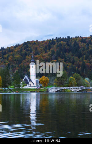 Clocher de l'église et le pont de pierre, à lac de Bohinj dans Ribicev village alpin Laz, Slovénie Banque D'Images